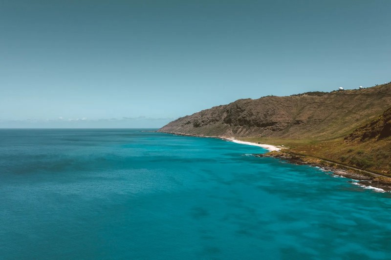 The rugged volcanic rock coastline of Hawaiʻi Volcanoes National Park facing the Pacific Ocean.