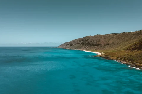The rugged volcanic rock coastline of Hawaiʻi Volcanoes National Park facing the Pacific Ocean.