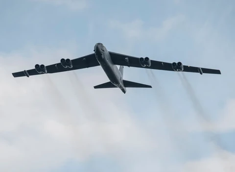 A long-range U.S. Air Force bomber preparing for departure from an active military airfield runway.